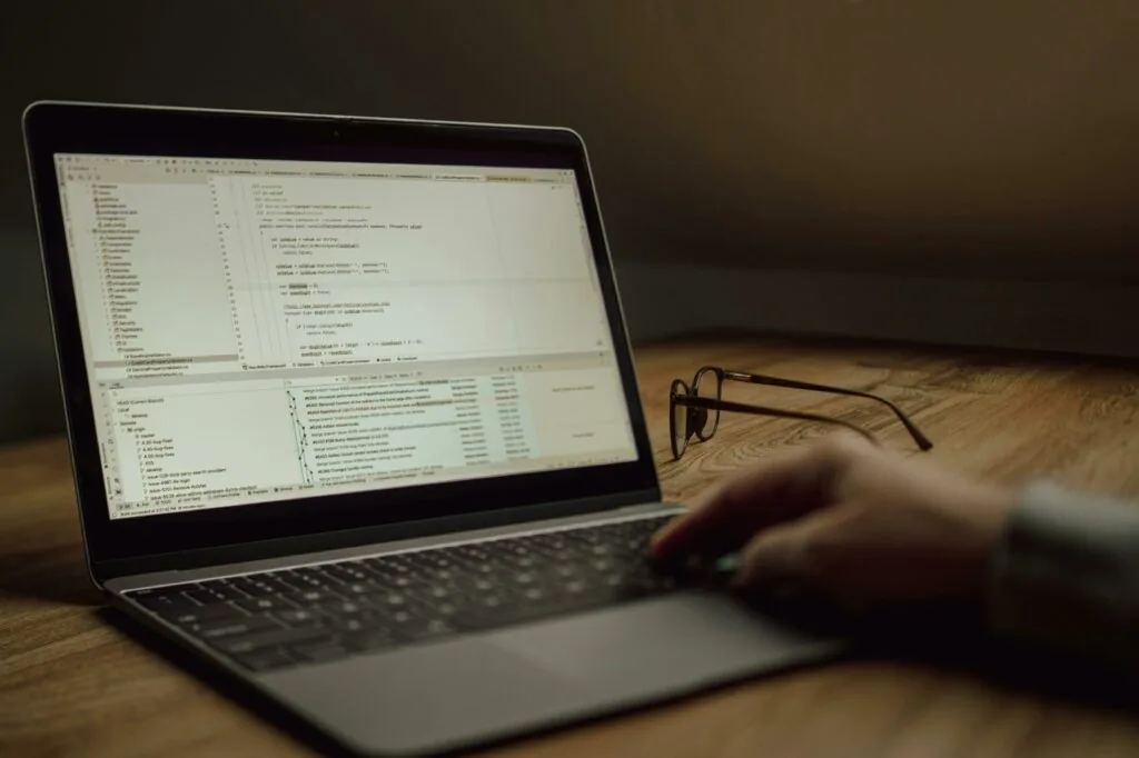 IDE_developpeur_pc Développeur senior relisant une pull request générée par IA sur deux écrans